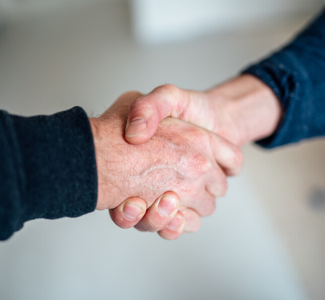 Zwei Hände reichen einander und stehen symbolisch für Hilfe, Vertrauen und Gewaltpräventionsberatung.