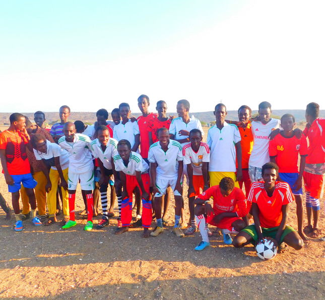 Afrikanische Menschen in Fußballtrikots stehen gemeinsam als Mannschaft aufgestellt da.