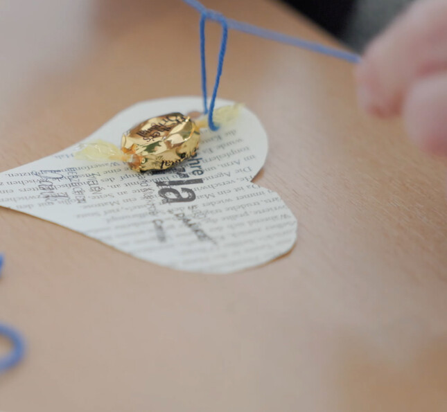 Handgefertigte Papierkarte mit Herzform und kleinem Geschenk als Ergebnis eines kreativen Beschäftigungsangebots.