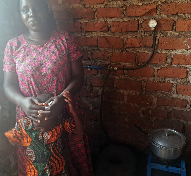 Eine Person nutzt eine Kochstelle, die über eine Biogasanlage mit Gas versorgt wird.